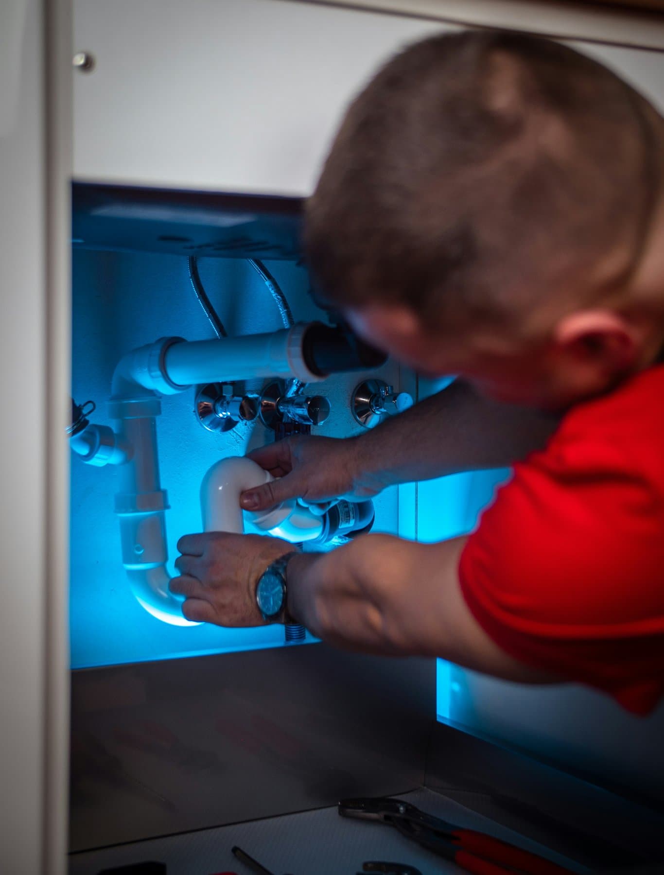 A plumber repairing a fixture in a home